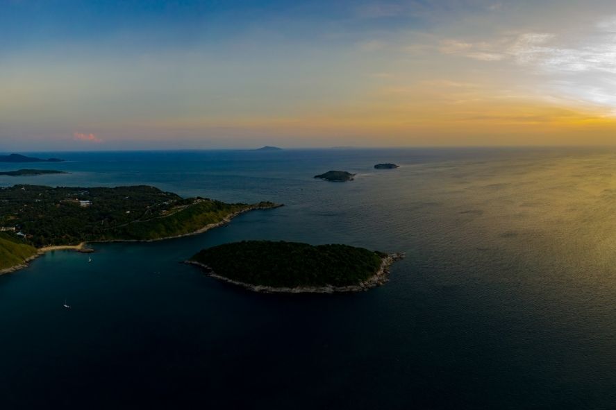 aerial view of nai harn beach with calm water and soft sunset light